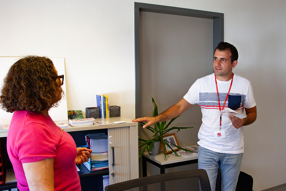 Ein Mann und eine Frau stehen in einem Büro und unterhalten sich. (Quelle: BAMF) Ein Mann und eine Frau stehen in einem Büro und unterhalten sich.