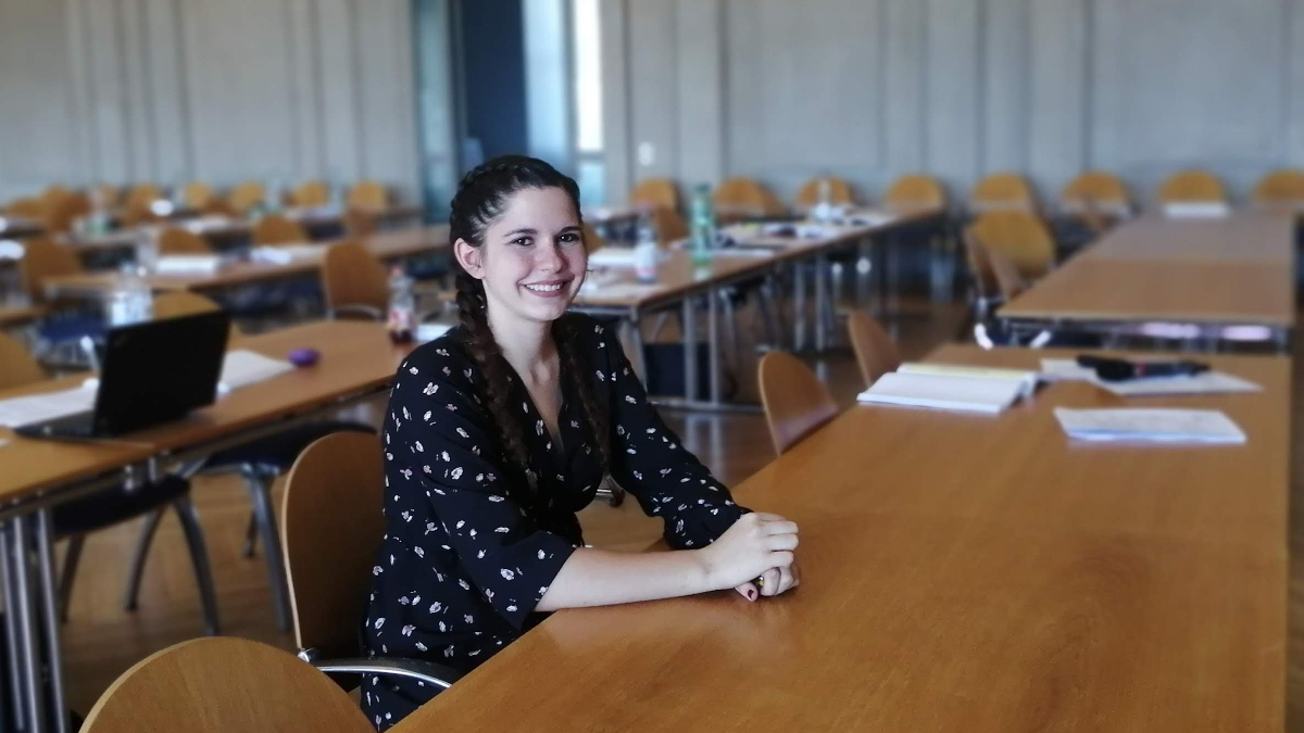 Eine junge Frau sitzt in einem Konferenzsaal. (Quelle: Ramsauer) Eine junge Frau sitzt in einem Konferenzsaal.