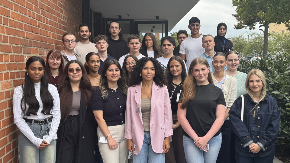 Junge Menschen stehen aufgereiht als Gruppe vor einem Gebäude.  (Quelle: BAMF) Junge Menschen stehen aufgereiht als Gruppe vor einem Gebäude.