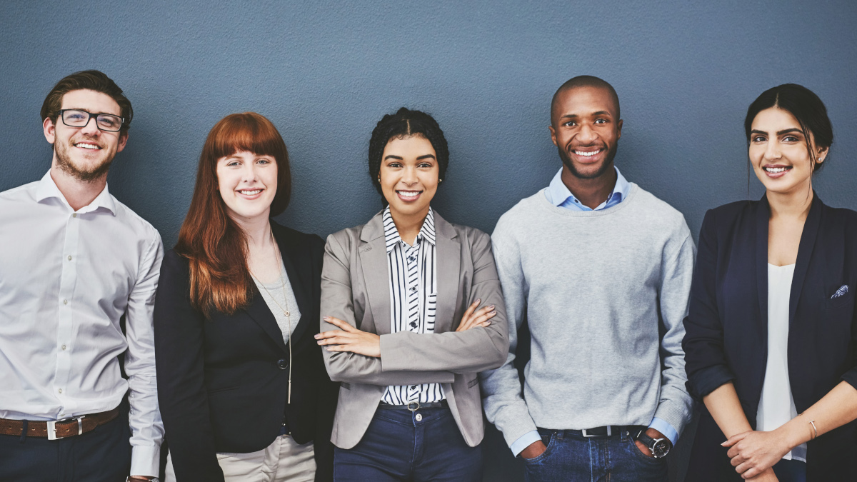 Eine Gruppe aus fünf jungen Menschen steht lächeln zusammen. (Quelle: iStock | Delmaine Donson) Eine Gruppe aus fünf jungen Menschen steht lächeln zusammen.