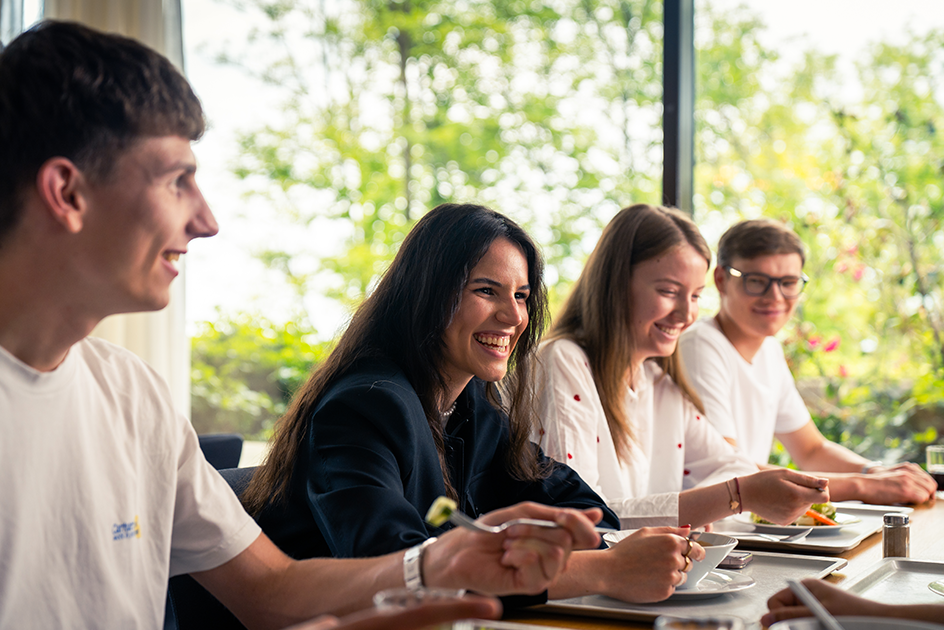 Zwei junge Frauen und zwei junge Männer sitzen an einem gedeckten Tisch in einer Kantine, essen und lächeln.  (Quelle:  ©  Deutsche Bundesbank) Zwei junge Frauen und zwei junge Männer sitzen an einem gedeckten Tisch in einer Kantine, essen und lächeln.