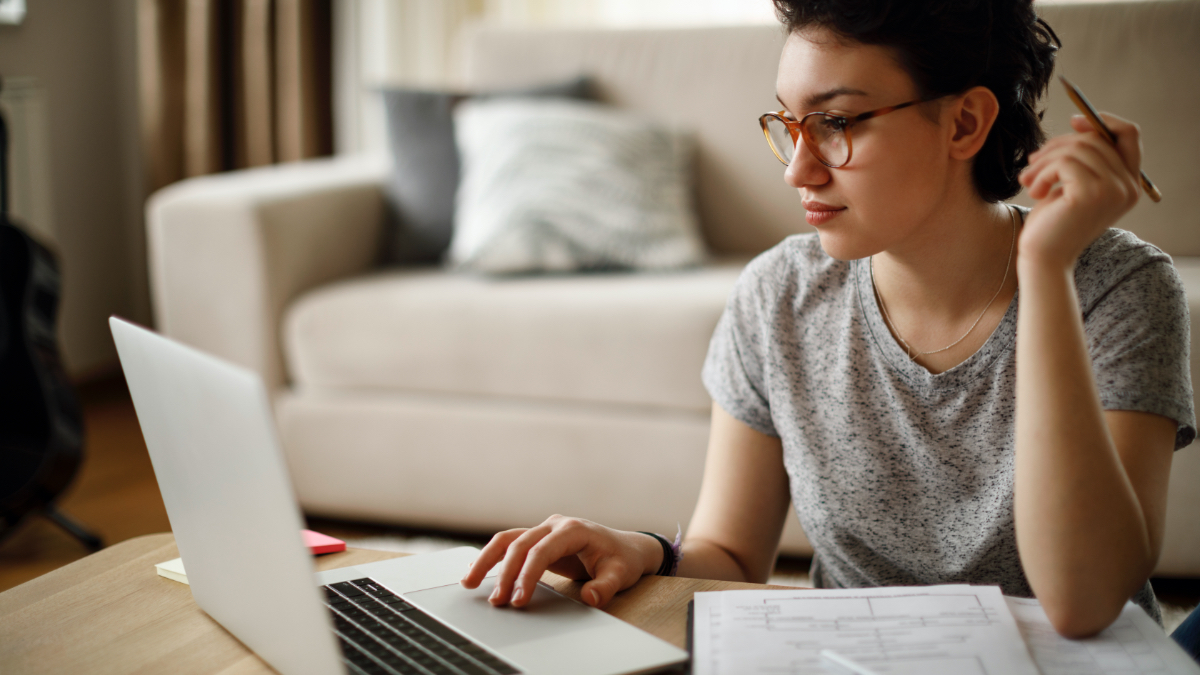Eine dunkelhaarige Frau sitzt an einem Tisch vor einem Laptop und hält in einer Hand einen Bleisitft. (Quelle: gettyimages | damircudic) Eine dunkelhaarige Frau sitzt an einem Tisch vor einem Laptop und hält in einer Hand einen Bleisitft.