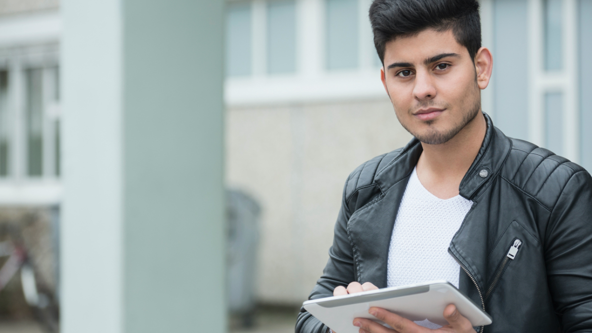 A young man is holding a tablet.  (Джерело: gettyimages | Niedring|Drentwett) A young man is holding a tablet.