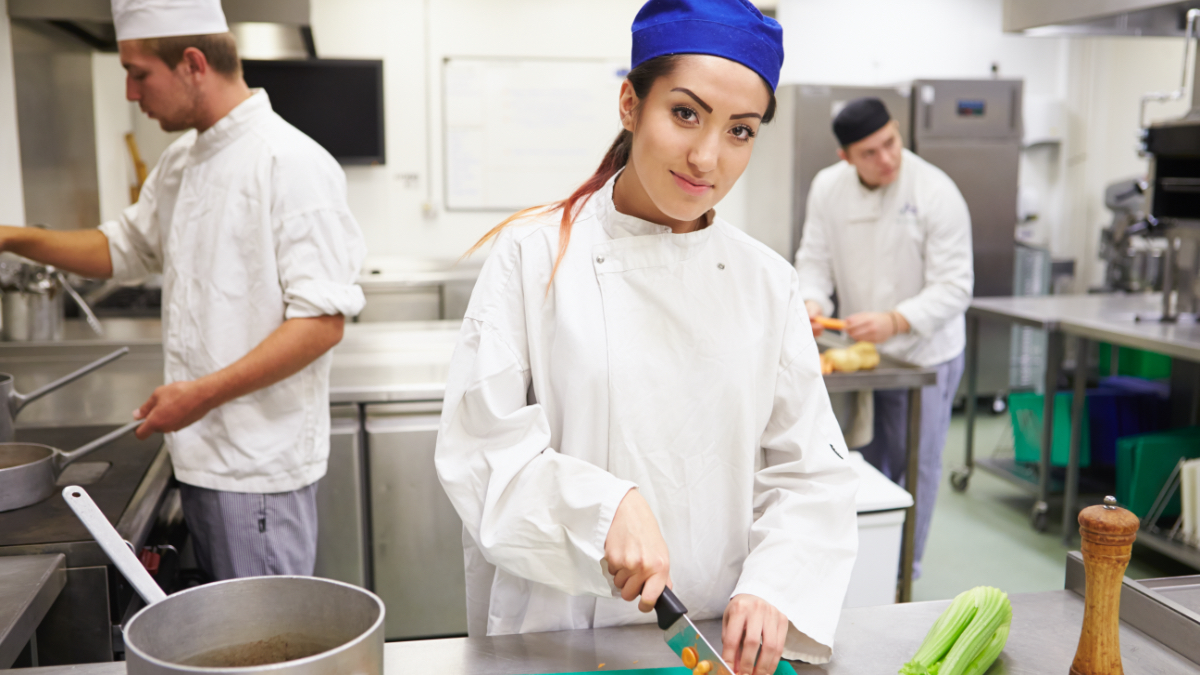 Three young people in a kitchen cooking and cutting vegetables. (Джерело: iStock | monkeybusinessimages) Three young people in a kitchen cooking and cutting vegetables.